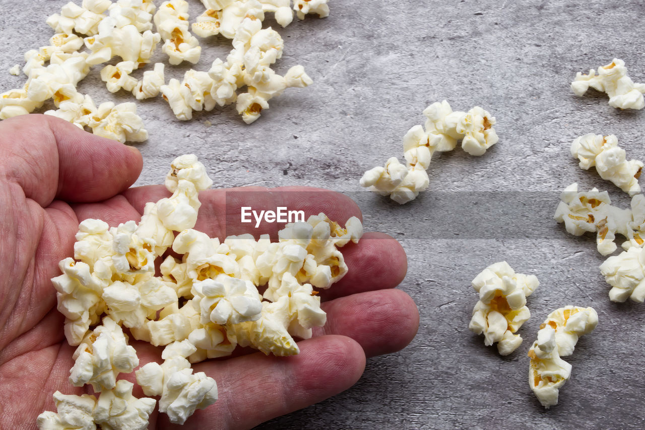 kettle corn, popcorn, hand, snack, food, food and drink, one person, holding, freshness, yellow, produce, high angle view, lifestyles, close-up