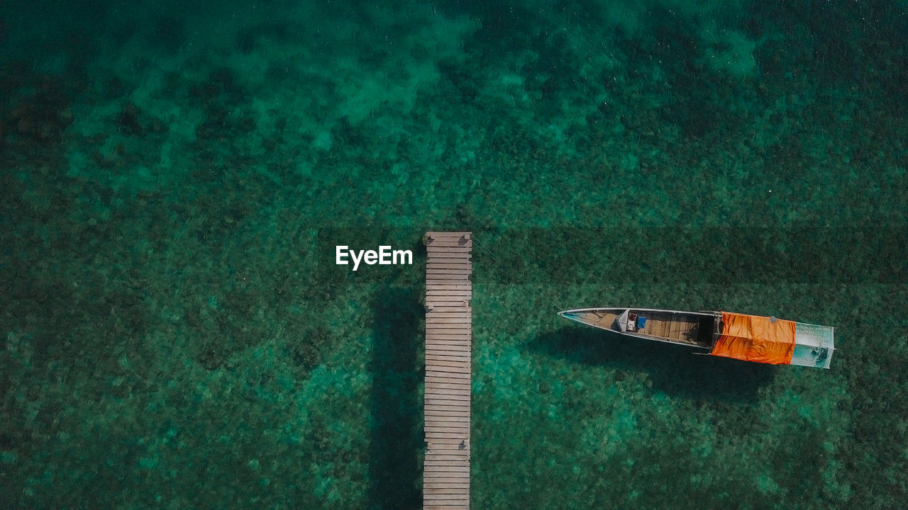 Aerial view of boat moored at pier in sea