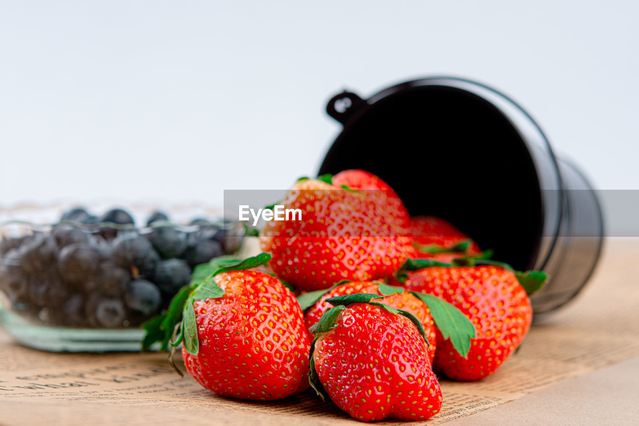 Red fresh strawberry in a bowl on wood background