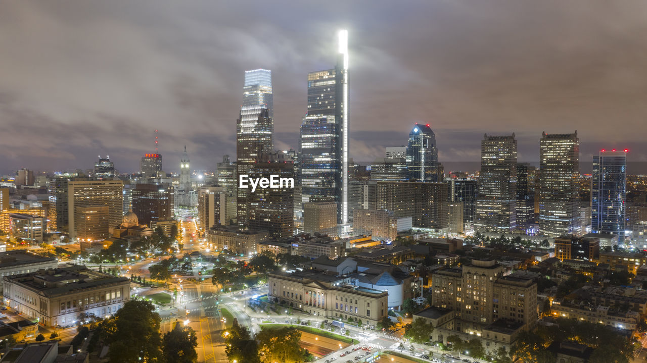 Illuminated buildings in city against sky at night