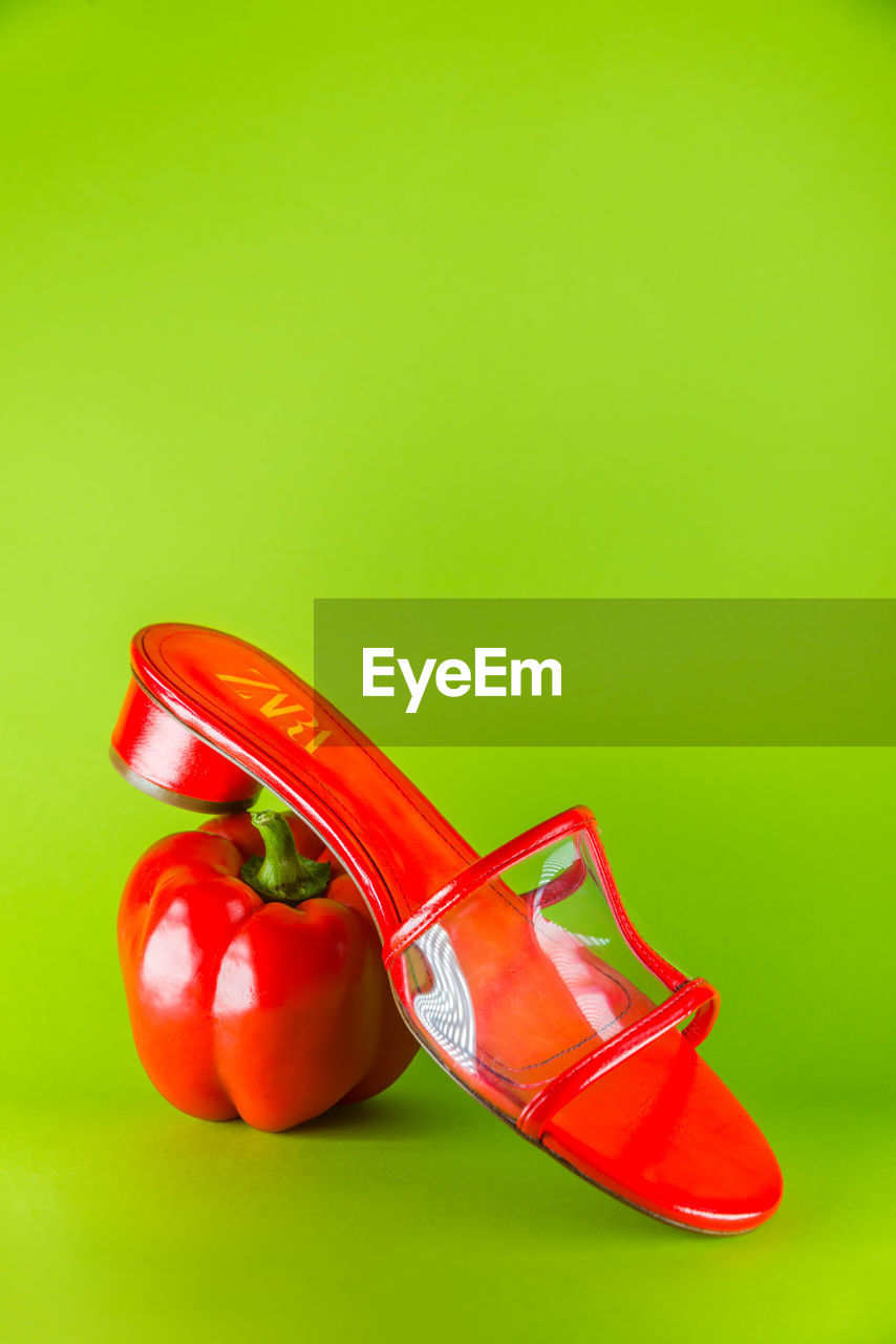 CLOSE-UP OF RED SHOES OVER COLORED BACKGROUND