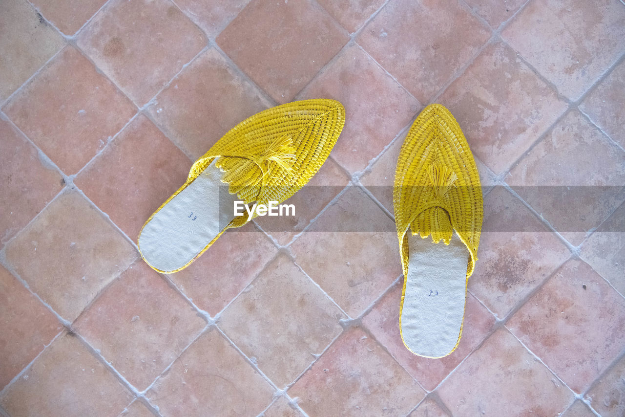 Yellow slippers on a brick floor