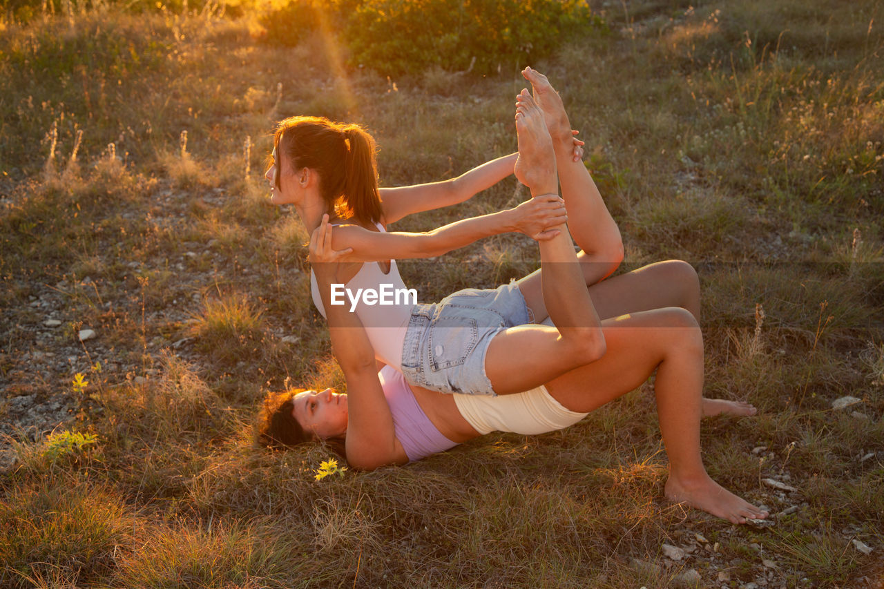 side view of woman sitting on grassy field at park