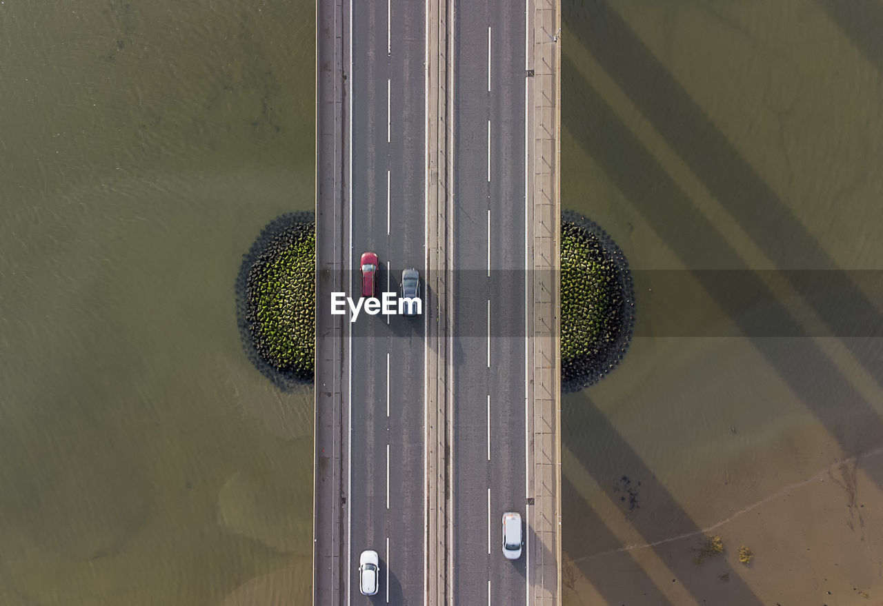 View from a drone looking down on traffic on a road bridge crossing a large river in suffolk, uk