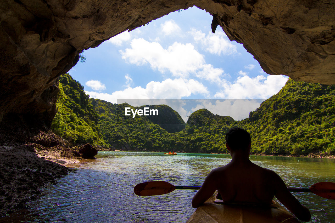 REAR VIEW OF MAN LOOKING AT VIEW OF MOUNTAIN