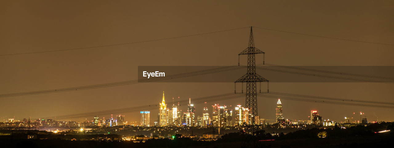 Silhouette electricity pylon against sky at night