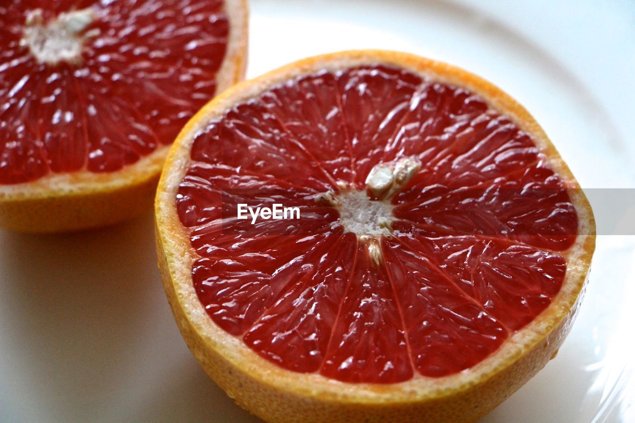 High angle view of halved grapefruits on plate