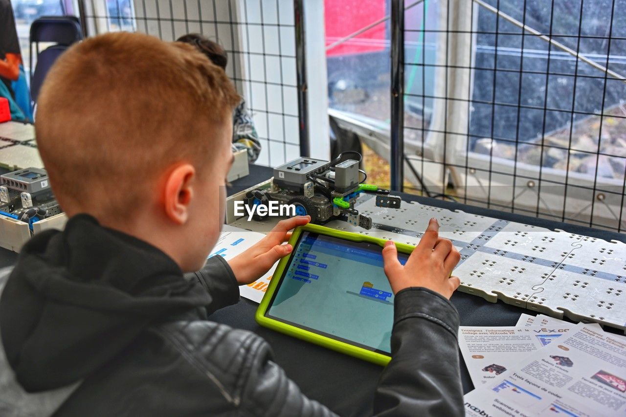 High angle view of boy programming a robot