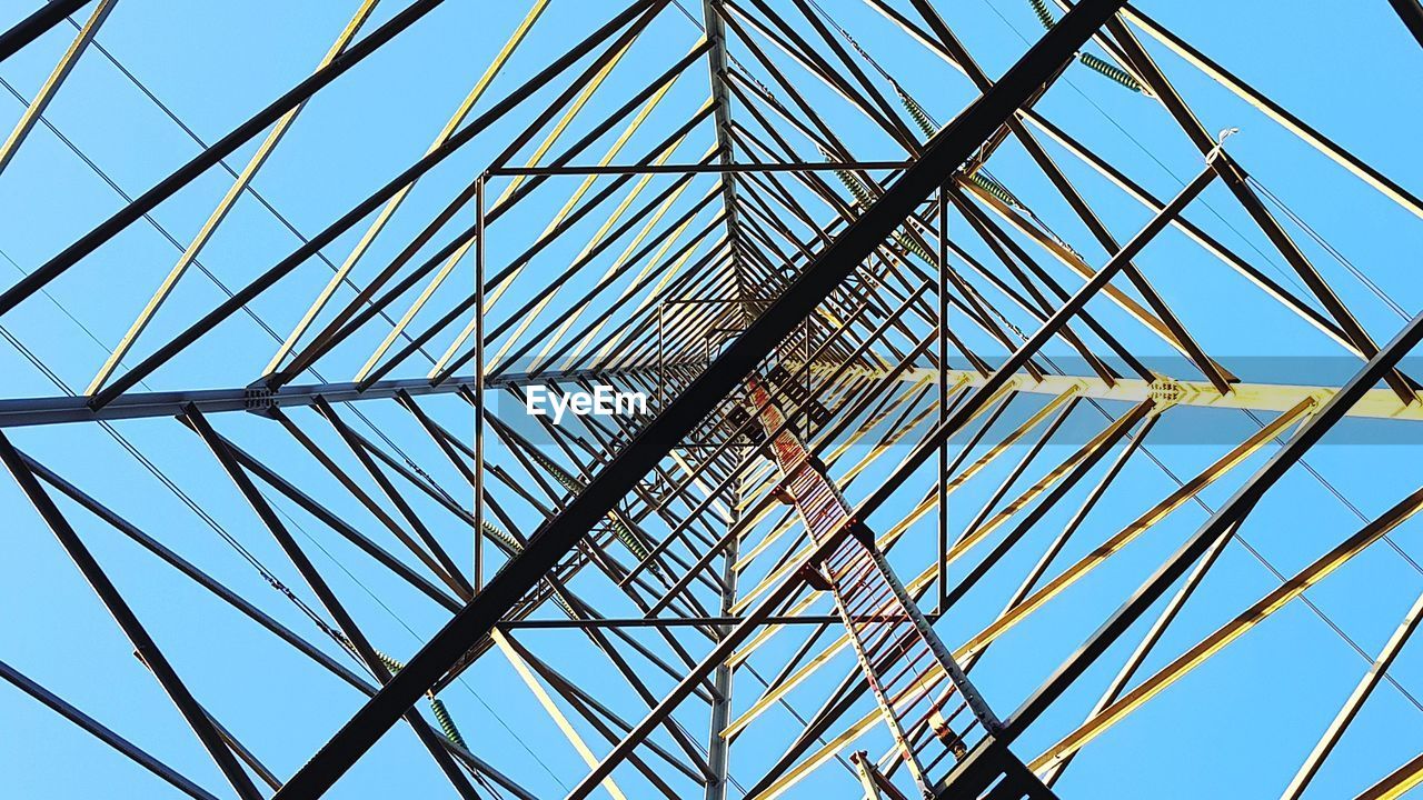 Low angle view of construction site against clear blue sky