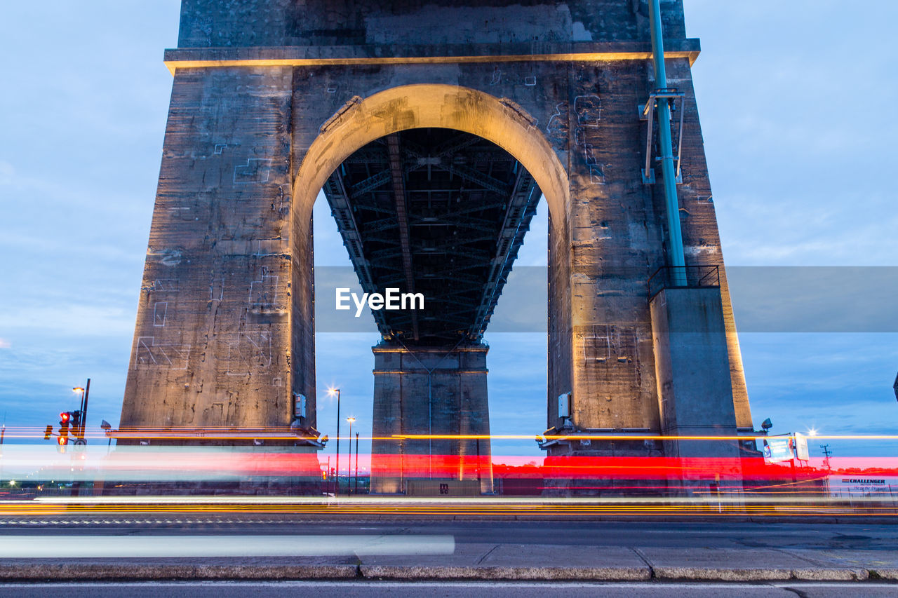 Blurred motion of light trails against bridge