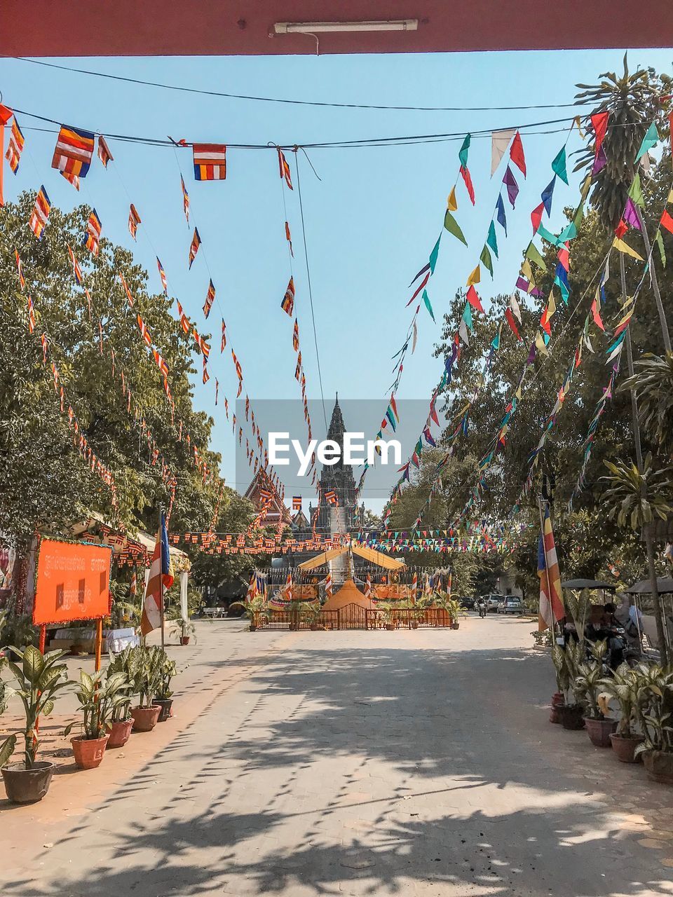 Buntings hanging amidst trees against temple