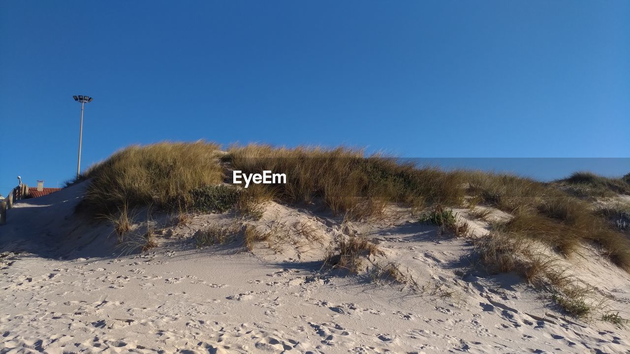 Panoramic shot of desert against clear blue sky