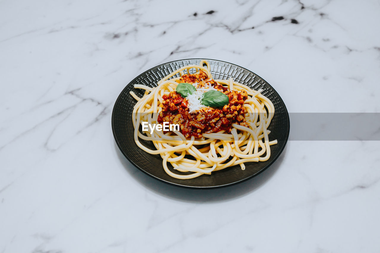 Pasta with bolognese sauce on black plate