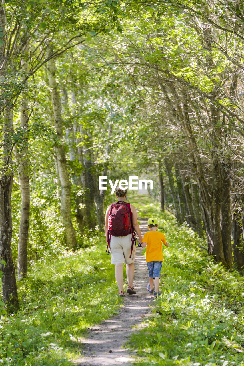 Mother with son walking through forest