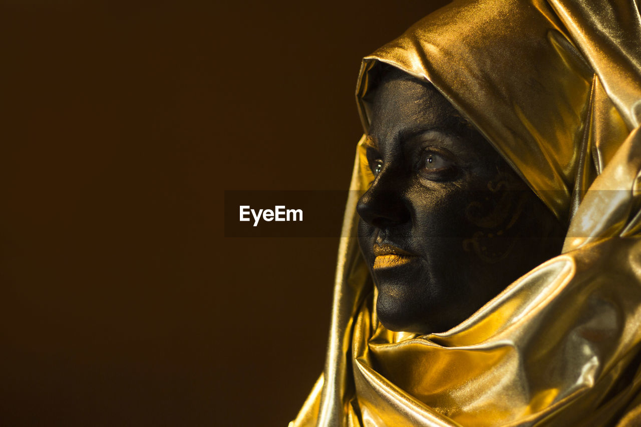 Portrait of a woman with black and gold make up, close up