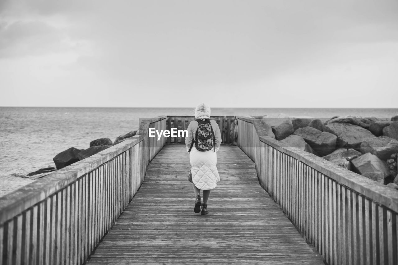 Lonely woman standing on a pier in denmark