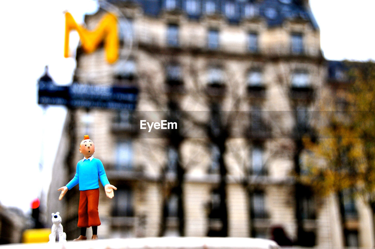 WOMAN WALKING ON STREET AGAINST BUILDINGS IN CITY