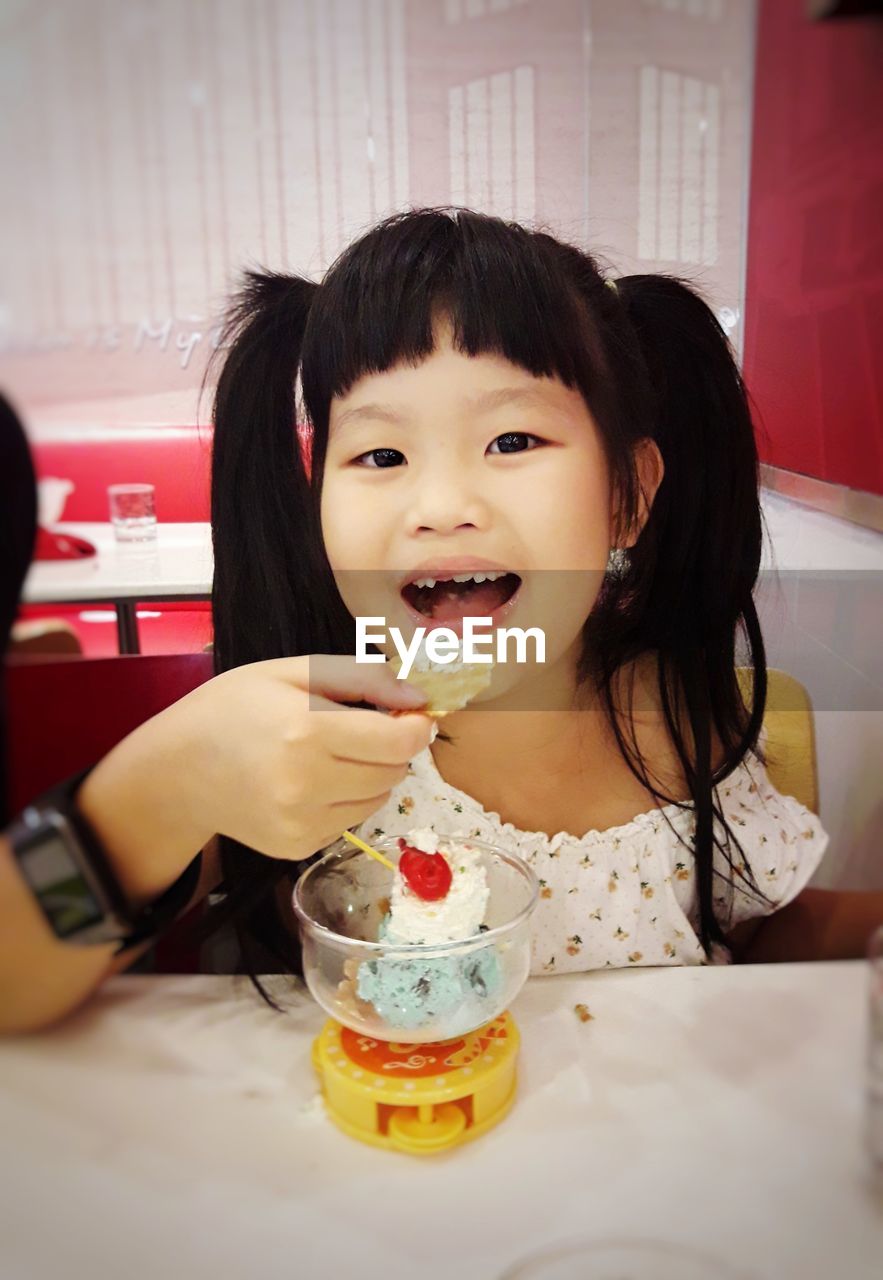 Portrait of girl eating dessert