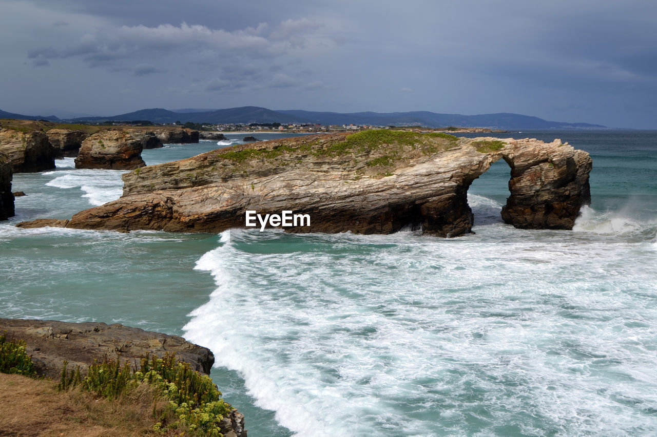 Rock formations in sea against sky