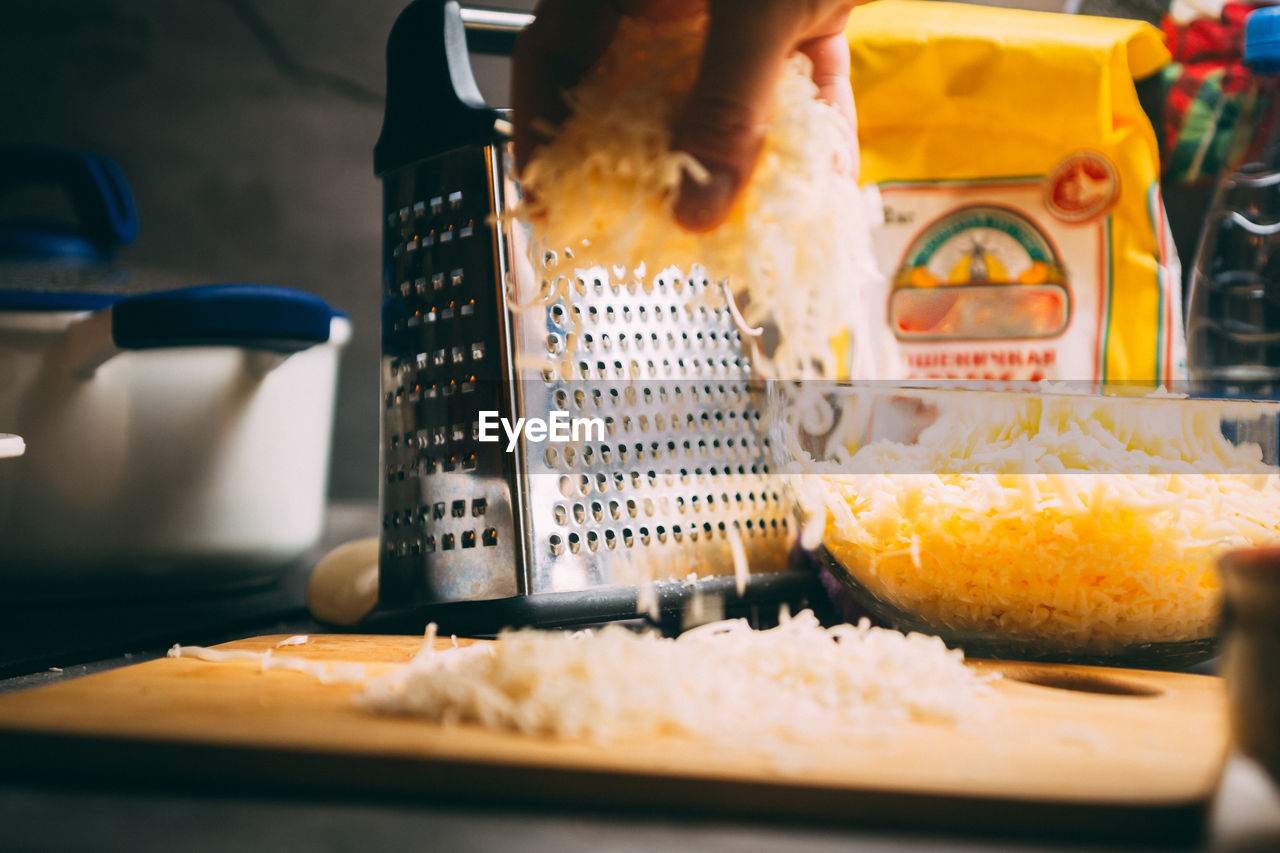 Cheddar cheese grated as close-up shot on an old vintage wooden table