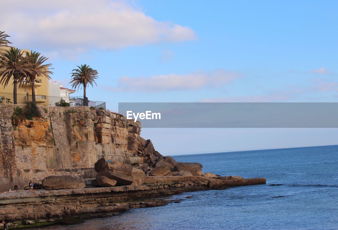 Rock formation on beach against sky