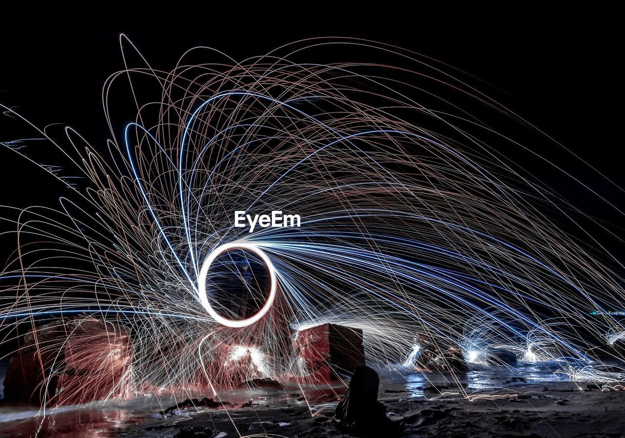 LIGHT TRAILS IN SKY AT NIGHT