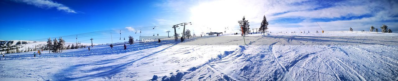 SNOW COVERED LAND AGAINST BLUE SKY