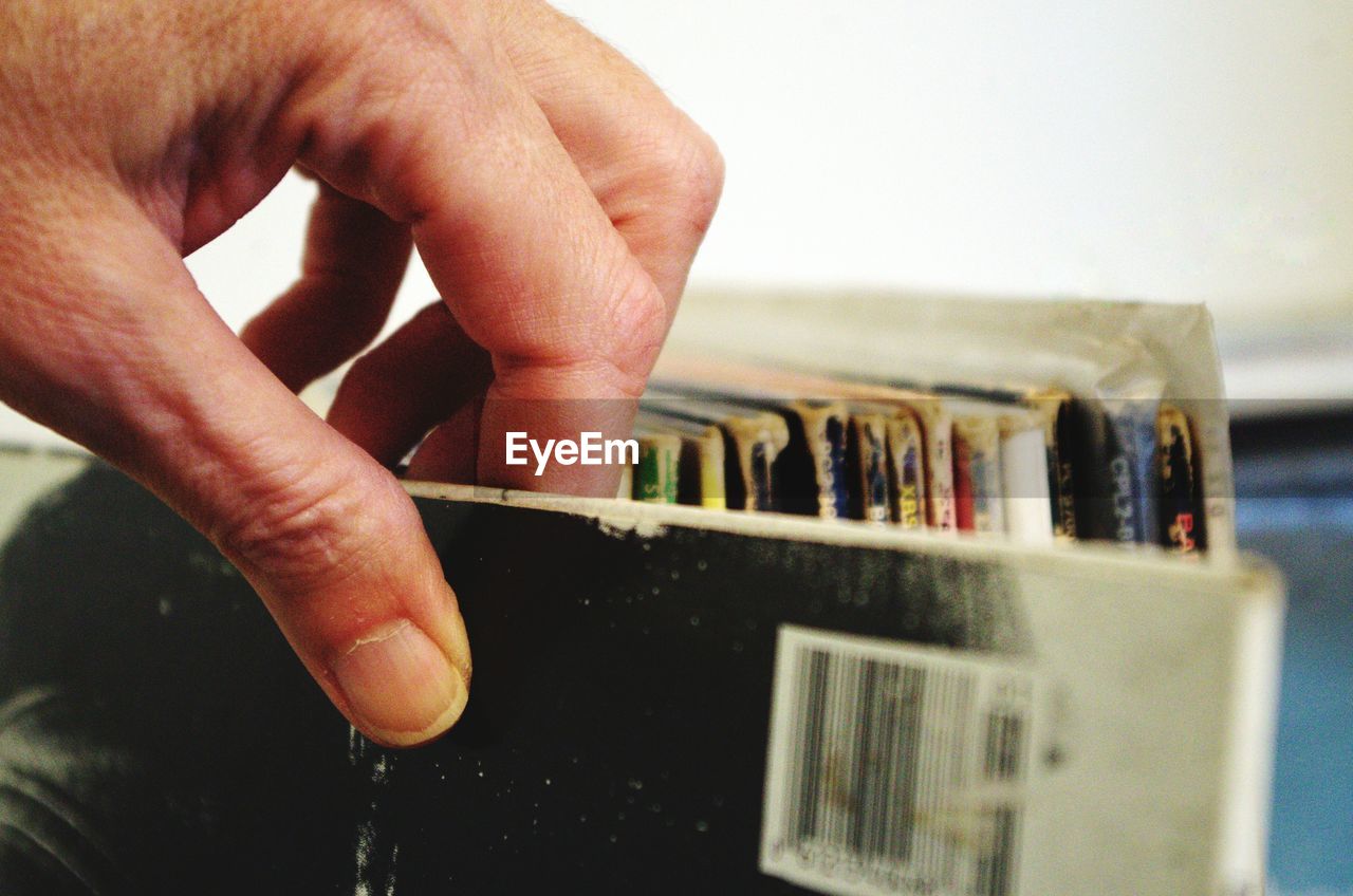 Cropped hand touching books on shelf