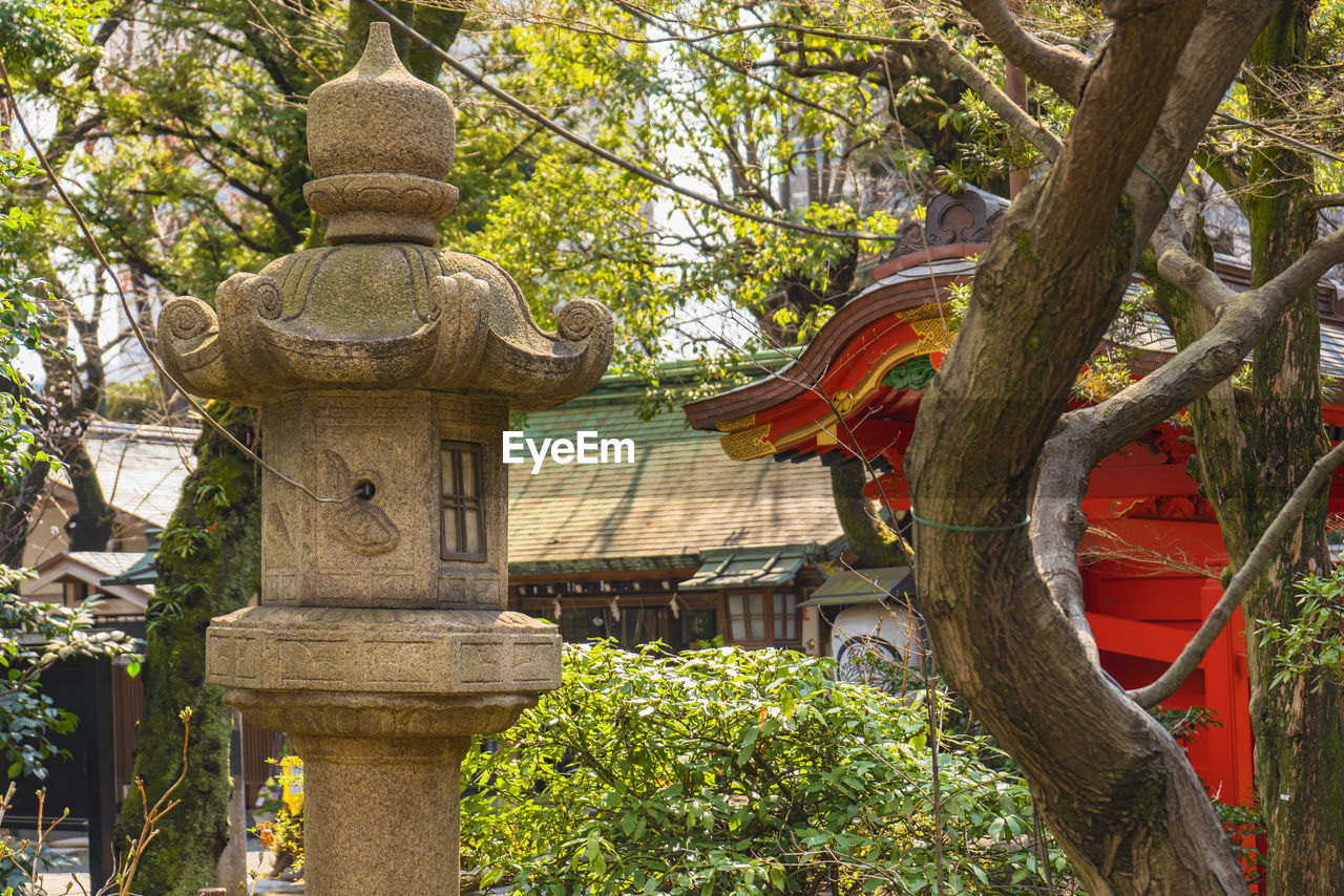 LOW ANGLE VIEW OF STATUE AGAINST TREES AT TEMPLE