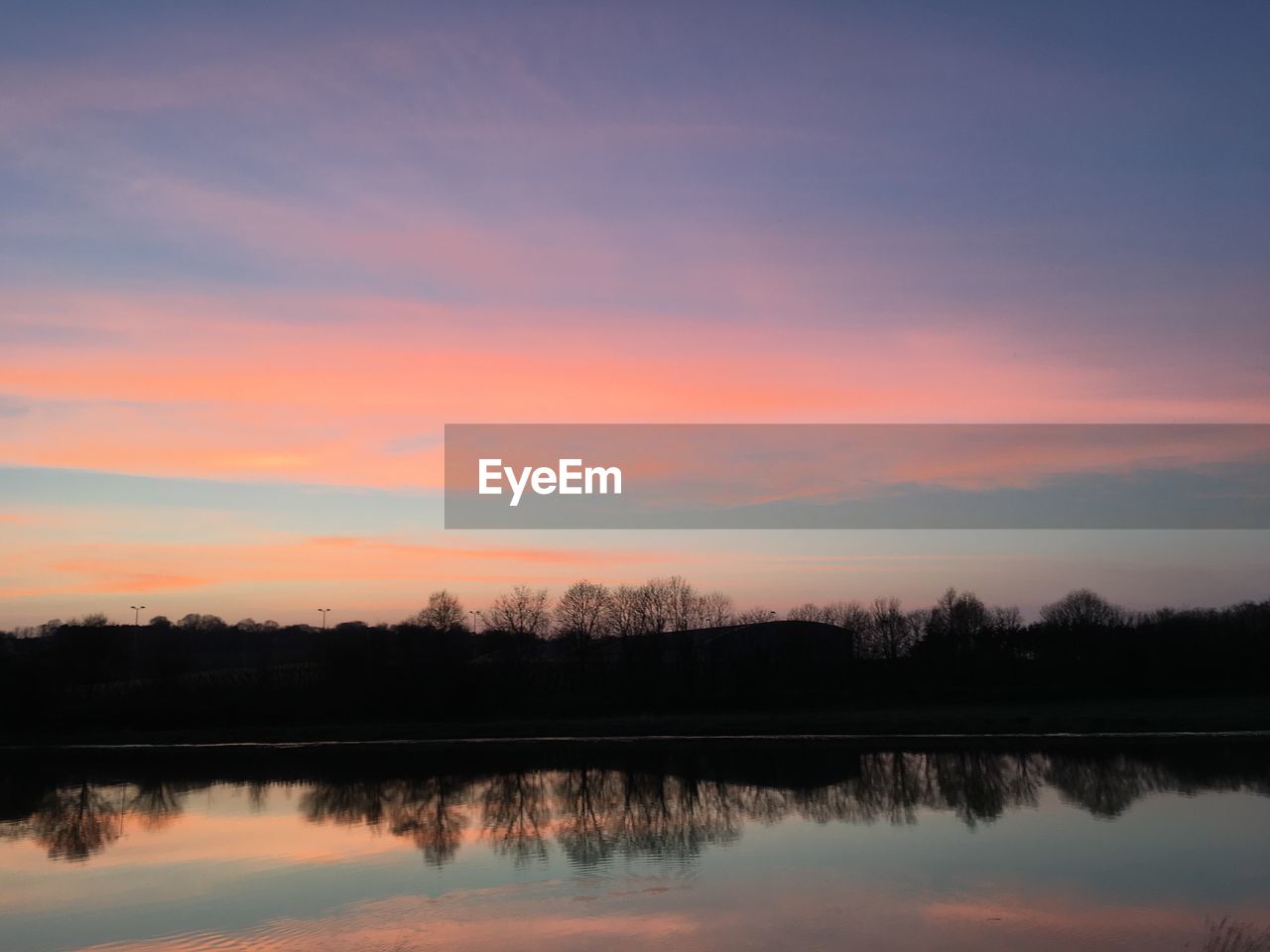 Scenic view of lake against sky during sunset