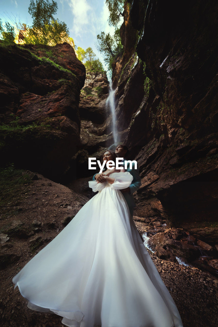 Couple in love against the backdrop of a waterfall. honeymoon trip. happy couple in the mountains