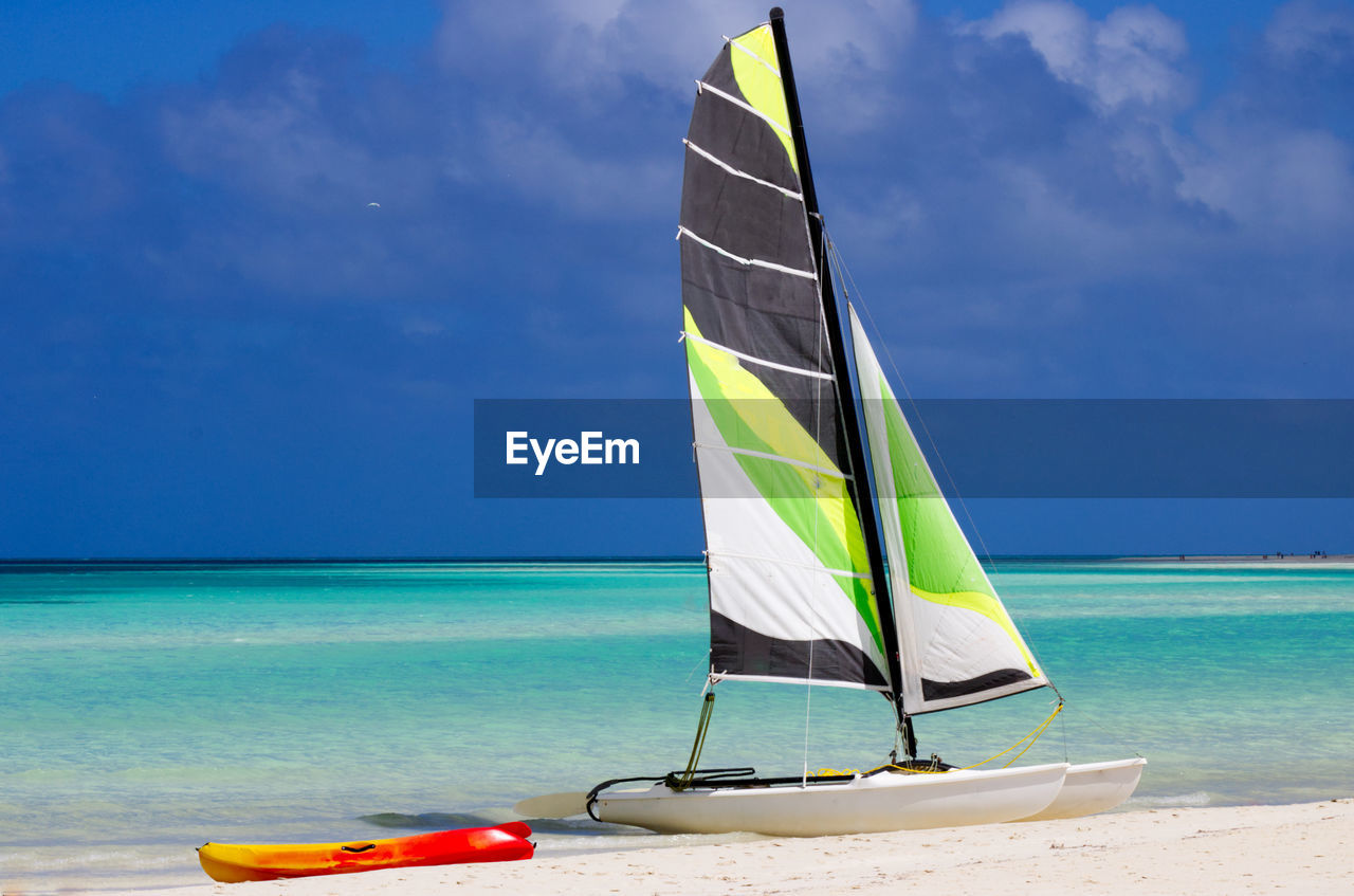 Scenic view of beach against sky with catamarans on the beach
