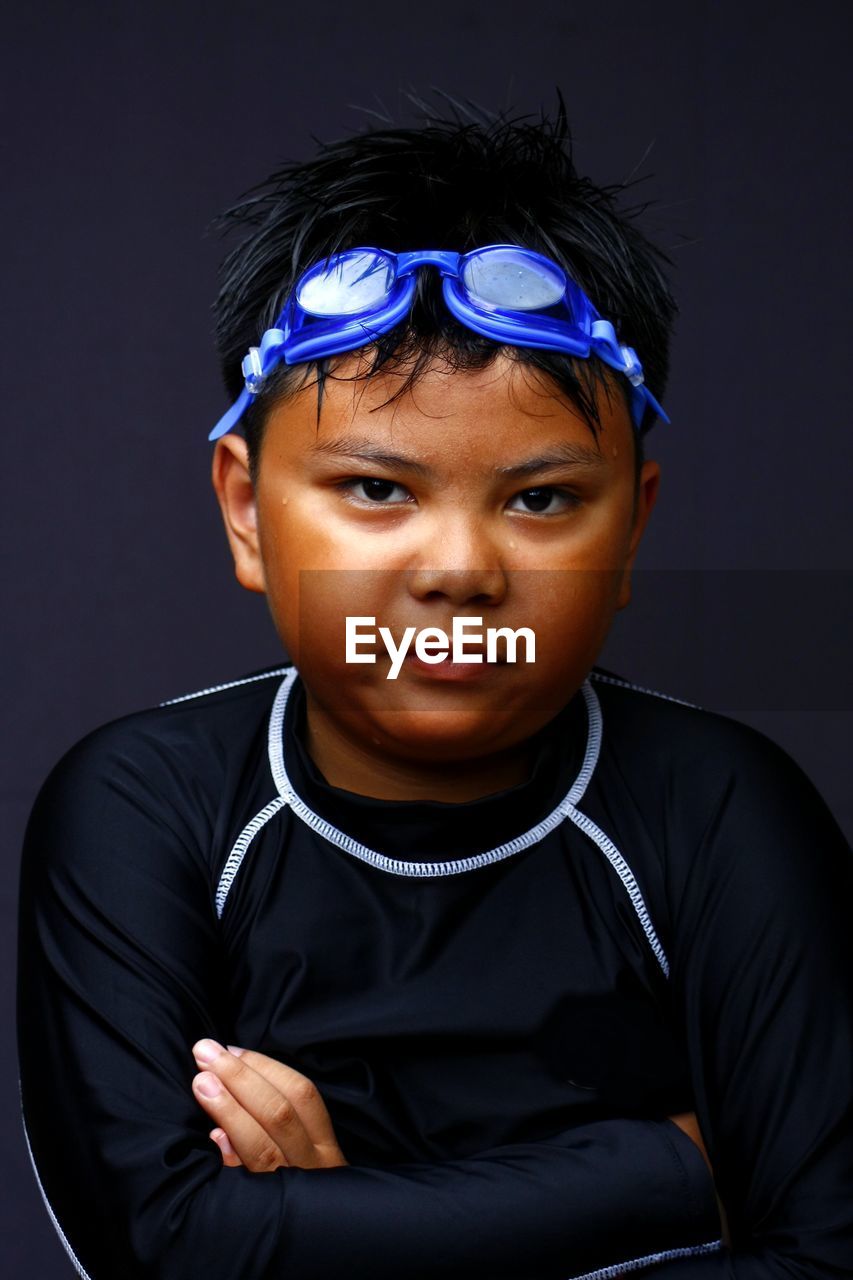 Close-up portrait of boy against black background