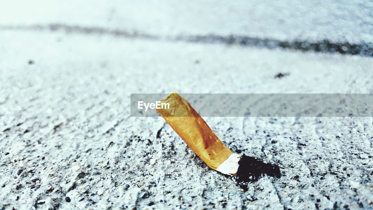 High angle view of cigarette on sand