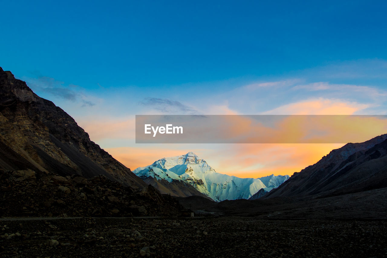 Scenic view of snowcapped mountains against sky during sunset