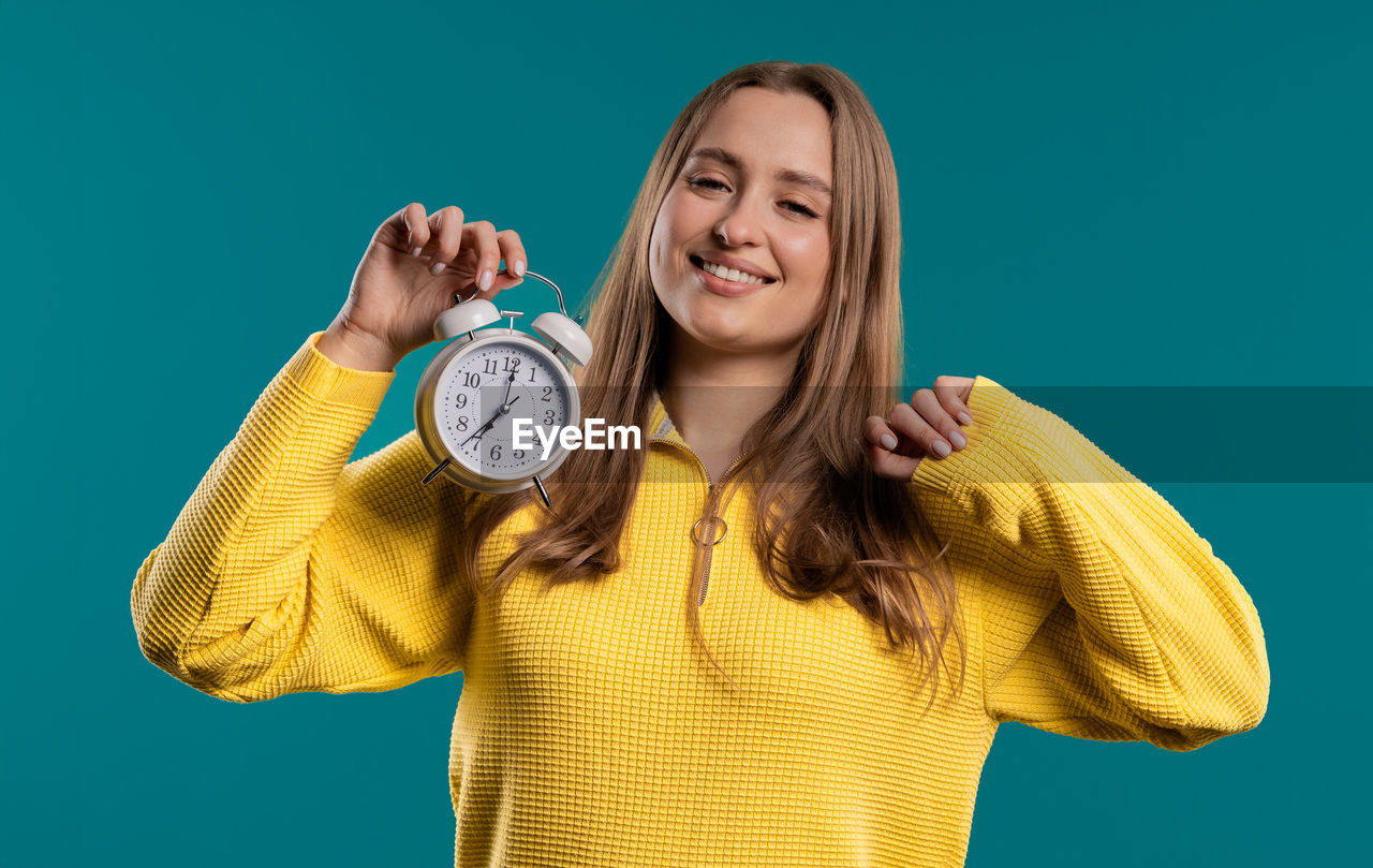 low angle view of clock on blue background