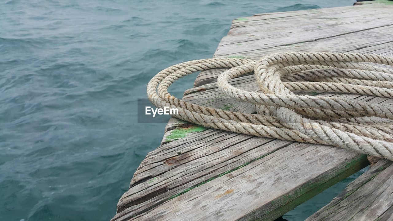 Close-up of rope on pier over sea