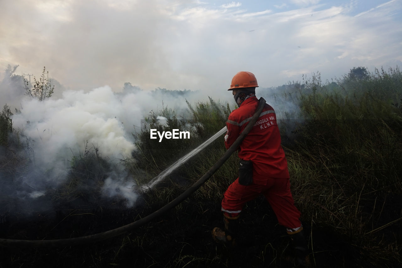 Rear view of firefighter working on field