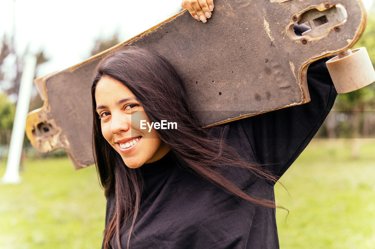 portrait of young woman standing against plants