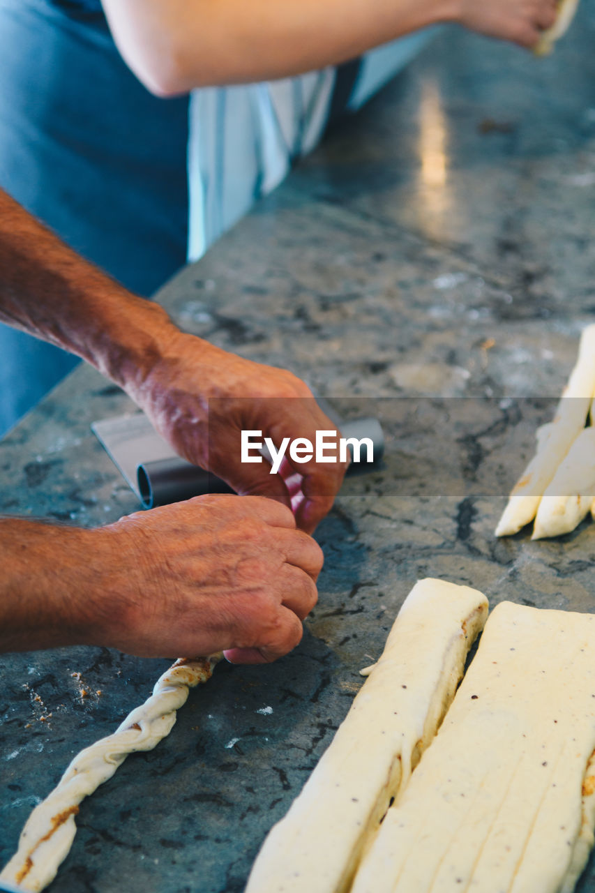 Cropped hand making cinnamon rolls