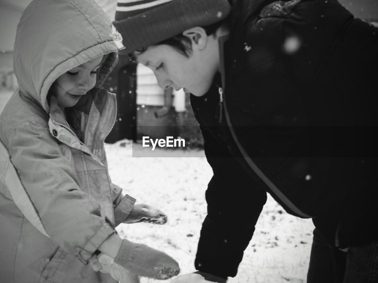 Close-up of siblings on field during snowfall