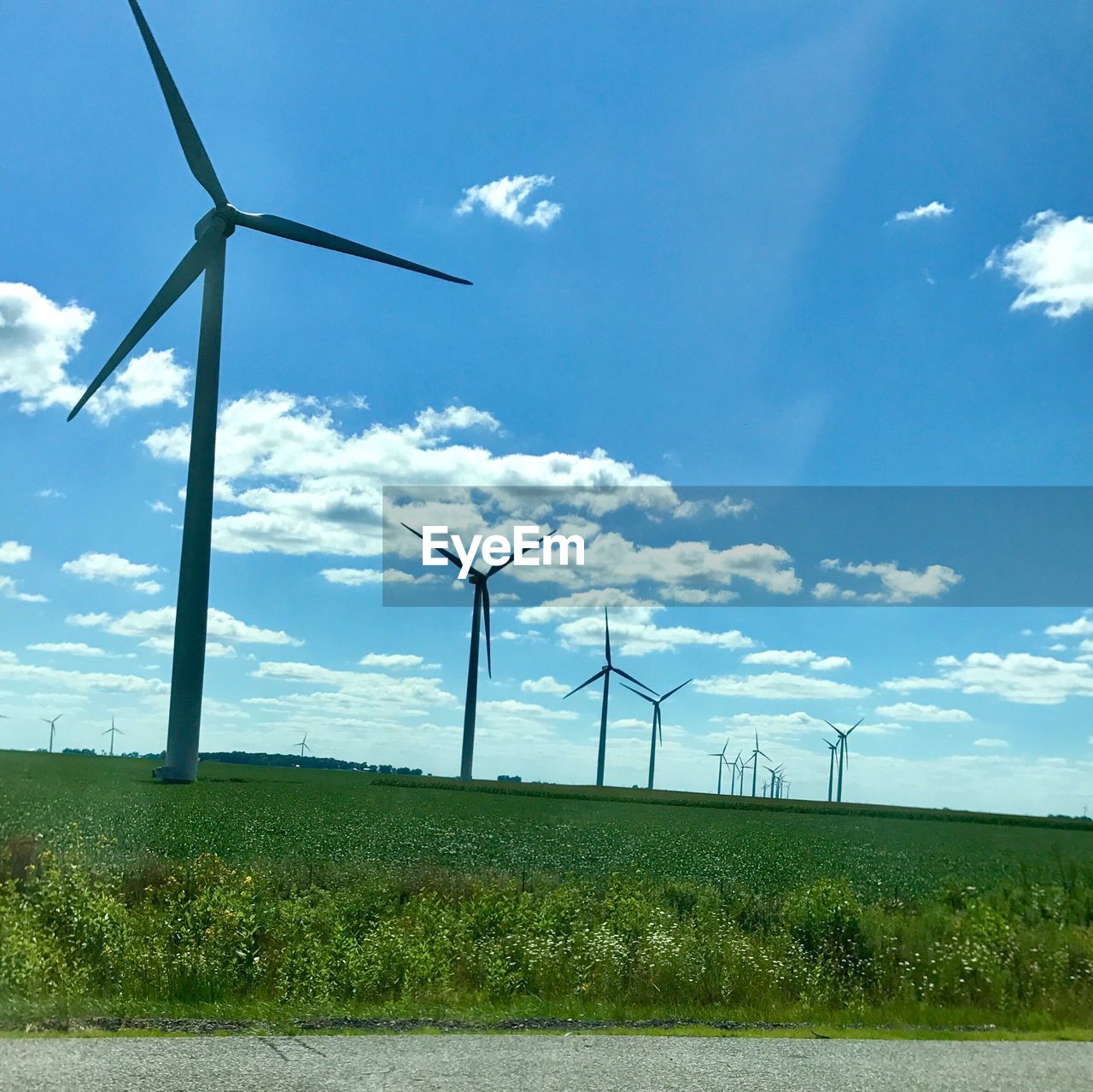 WIND TURBINES IN FIELD AGAINST SKY