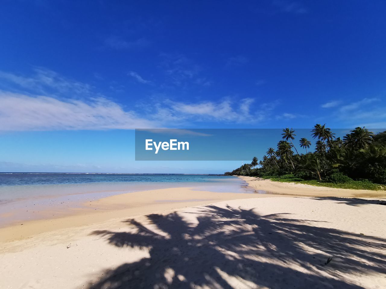 Scenic view of beach against blue sky