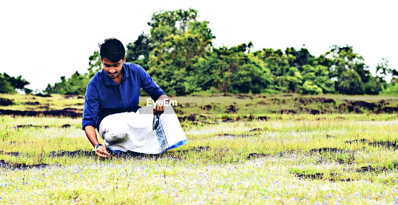 Man crouching on field