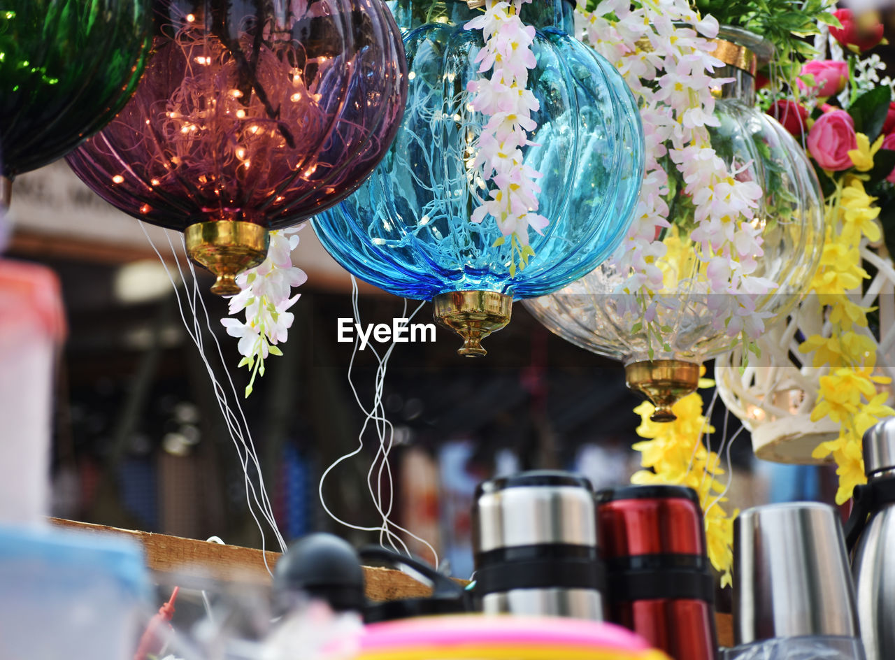 CLOSE-UP OF MULTI COLORED GLASS HANGING AT MARKET STALL