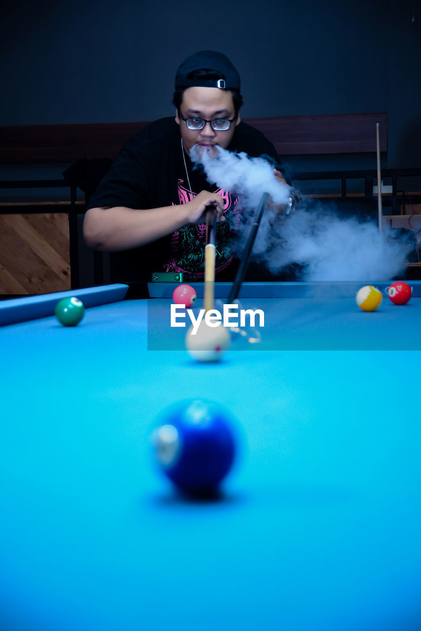 midsection of man playing pool