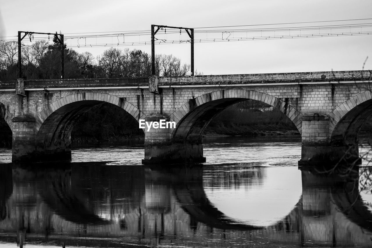 bridge, water, architecture, built structure, black and white, arch, river, monochrome, arch bridge, monochrome photography, transportation, reflection, nature, sky, no people, day, city, viaduct, travel destinations, outdoors, black, building exterior, waterway, waterfront