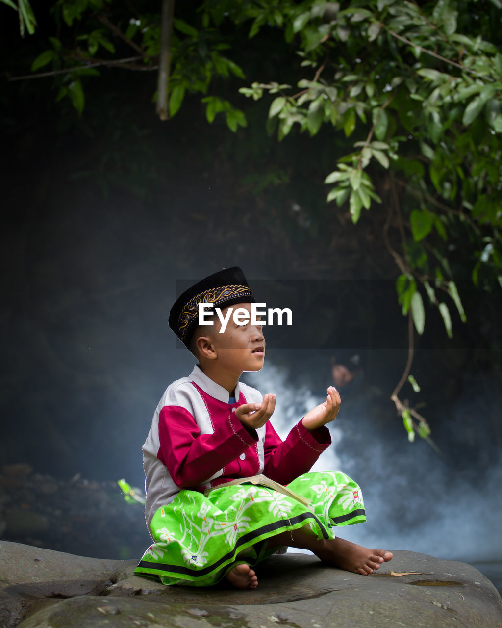 Girl looking away while sitting on plant