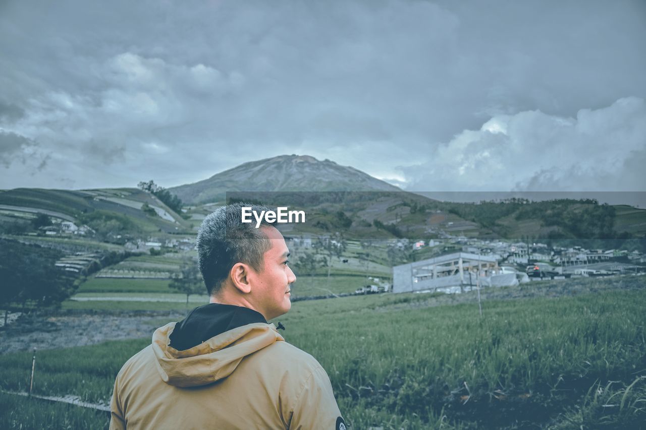 Man standing on field against mountains