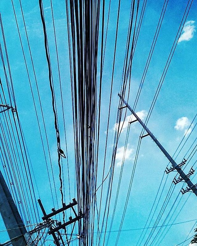 LOW ANGLE VIEW OF POWER LINES AGAINST BLUE SKY